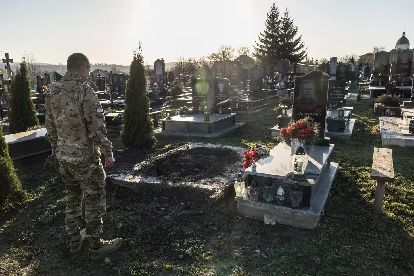 Фото дня: військовий з Львівщини повернувся з полону і прийшов на свою могилу